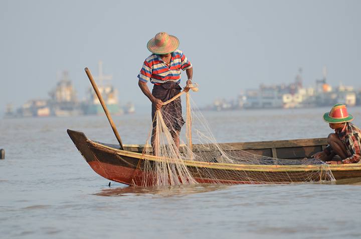 A man fishing with a net in Mon State. Photo: MOI