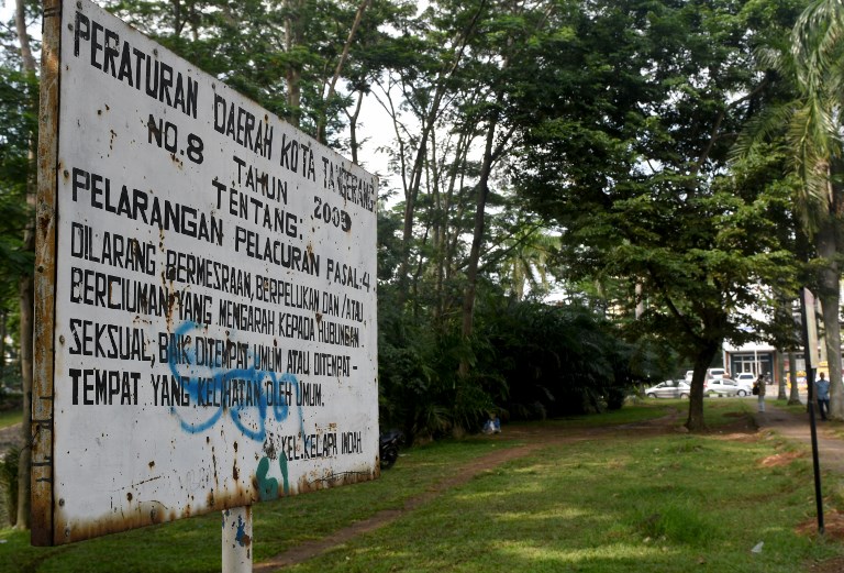 This photo taken on February 8, 2018 shows a signboard prohibiting prostitution or any kind of sexual acts including kissing or hugging at a park in Tangerang, in the suburbs of Jakarta.
Indonesia is pushing to clamp down on gay and pre-marital sex as part of a sweeping criminal law overhaul that critics blame on a wave of religious fundamentalism sweeping across the world’s biggest Muslim-majority nation. / AFP PHOTO / GOH CHAI HIN