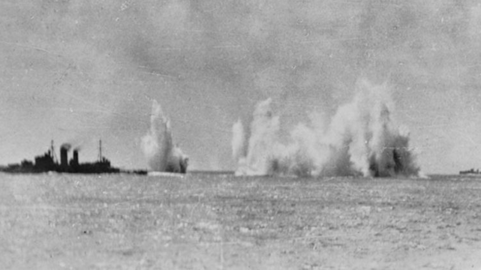 The Royal Navy cruiser HMS Exeter (68) and the Australian cruiser HMAS Hobart (D63) under aerial attack by Japanese aircraft in seas of South East Asia. A Dutch destroyer is visible at right. Most probably this image was taken as the ship was passing through the Gaspar Straights, Indonesia, 14-15 February 1942. Photo: Wikimedia Commons