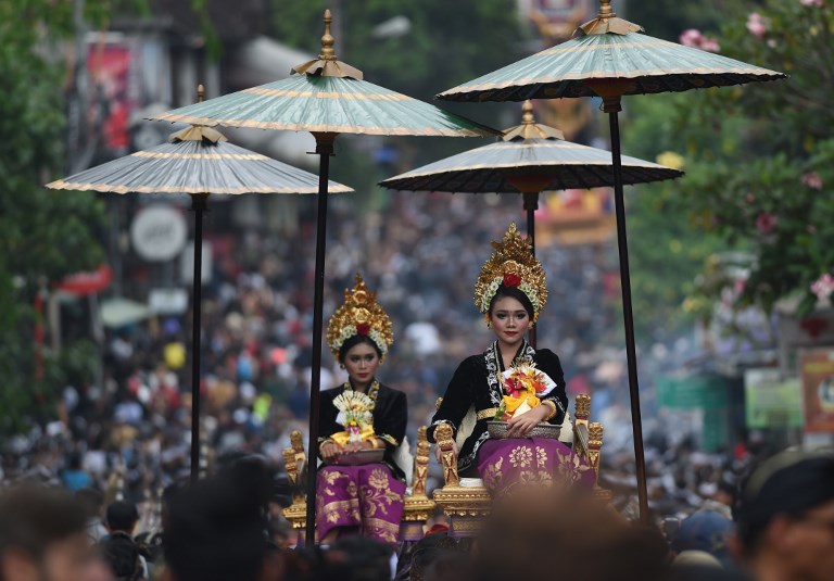 Two Balinese women wear traditional outfits during the cremation ceremony of a member of the royal family in Ubud, on Bali island on March 2, 2018. Photo: Sonny Tumbelaka/AFP