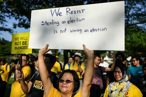 Protesters display placards during a rally organised by election reform group Bersih (Clean) against a bill to redraw electoral boundaries near Parliament House in Kuala Lumpur on March 28, 2018.
Malaysian lawmakers voted March 28 to redraw the electoral map in what critics slammed as a bid to rig looming polls, sparking angry protests outside parliament and fury from opposition MPs inside. / AFP PHOTO / Mohd RASFAN