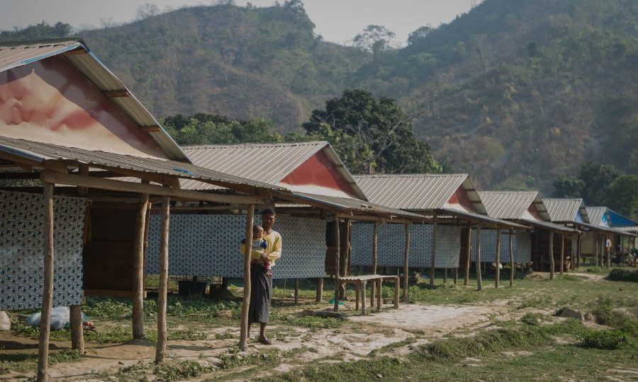 This photo taken on March 8, 2018, shows a man holding his child in Koe Tan Kauk village in Rathedaung Township, Rakhine State. / AFP PHOTO / PHYO HEIN KYAW /