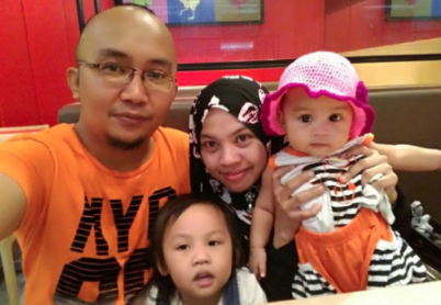 The mother with her deceased child (pink hat) via Utusan/Facebook