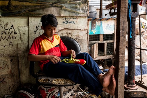 This picture taken on March 7, 2018 shows Somad, 14, who lives in a crowded neighborhood of scavenger families in Bekasi, preparing to go train with Indonesia’s street children football team “Garuda Baru” in Bekasi, on the outskirts of Jakarta. AFP PHOTO / Elisabetta ZAVOLI