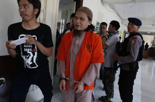 Indonesian Islamist preacher, Kiki Muhammad Iqbal (2nd L – in orange) is escorted to a court room at the North Jakarta court in Jakarta on April 9, 2018.
The convicted mastermind of a deadly twin bombing in Jakarta last year claimed by the Islamic State group was sentenced to nine years in prison on April 9. / AFP PHOTO / MELVINAS PRIANANDA