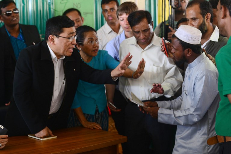 Myanmar Social Welfare Minister Win Myat Aye (L) talks to Rohingya refugees during his visit to the Kutupalong refugee camp in Bangladesh’s Ukhia district on April 11, 2018. / AFP PHOTO / MUNIR UZ ZAMAN