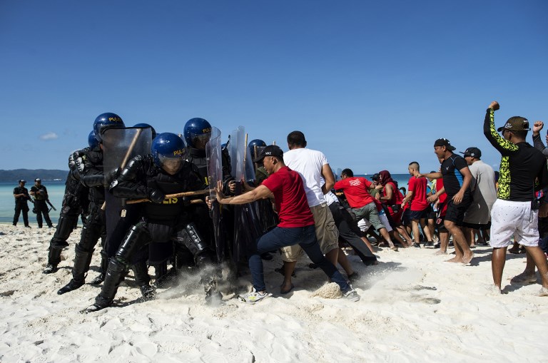 Mock protesters scuffle with anti-riot police during a security measures exercise on the Philippine island of Boracay island on April 25, 2018.
Police with assault rifles patrolled entry points to Boracay island on April 24 just days before a six-month shutdown and clean-up of one of the Philippines’ top tourist attractions. Police conducted exercises simulating clashes with protesters, terrorist attacks and a hostage incident even as they said there was no specific threat.  / AFP PHOTO / NOEL CELIS