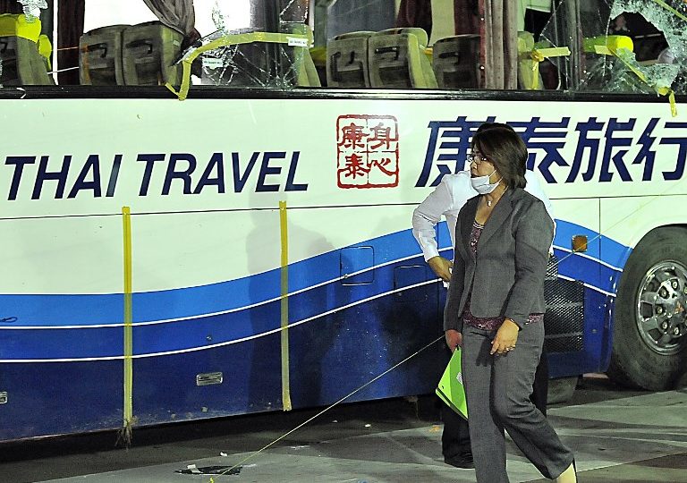 Leila de Lima (C) the Philippine Justice Secretary and head of the panel of investigators on the deadly hostage-taking,walks outside of the tourist bus that was the scene of the deadly hostage incident in which eight Hong Kong residents were killed, during an inspection by the panel of investigators, at a police camp to where the bus was taken, in Manila on September 8, 2010. The inquiry, which was due to wind up later September 8, has uncovered a litany of mistakes by police and other officials assigned to handle the hostage crisis. On September 7, the Philippine government said the media has agreed to new restrictions on covering police operations — including limits on live broadcasts. The various strings represent the trajectory of bullets that were shot. (Photo from AFP ) 