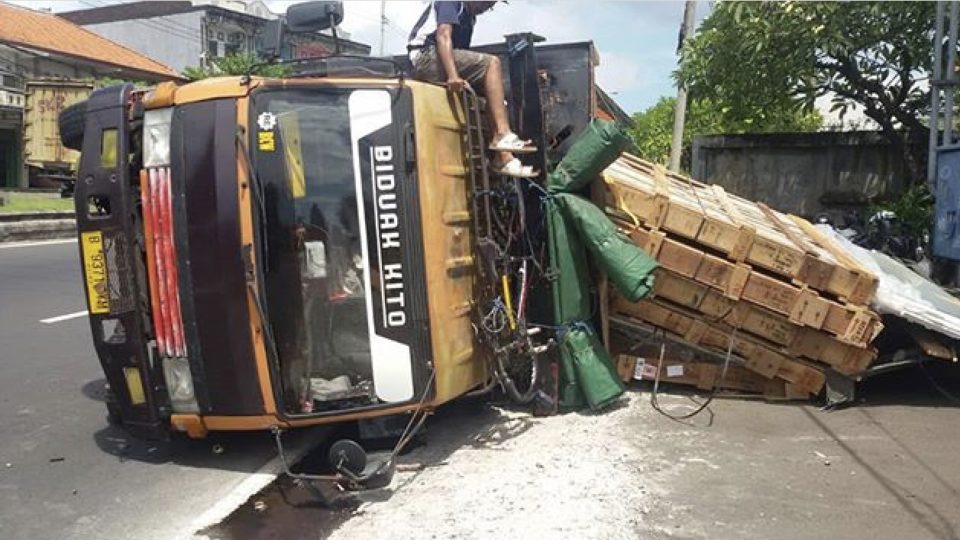 Sheets and sheets of glass shattered when the truck transporting the load tipped over on Bali’s Ngurah Rai By Pass. Photo: Lantas Resta Denpasar 