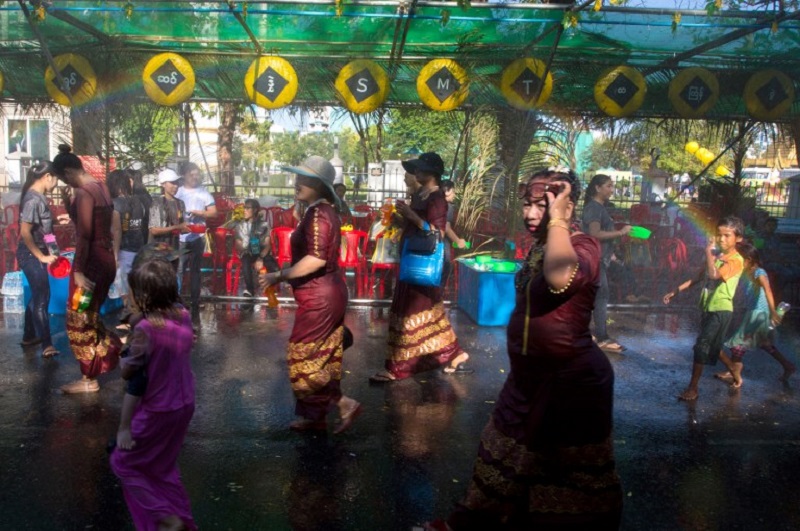 Myanmar women in traditional costumes are doused with water during a ceremony celebrating the Buddhist New Year, known locally as “Thingyan”, in Yangon on April 13, 2018. / AFP PHOTO / SAI AUNG MAIN