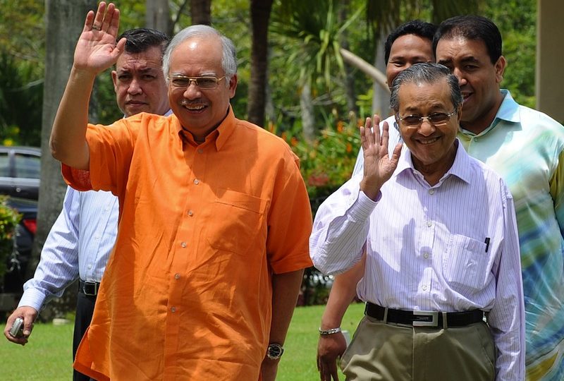 This file photo taken on April 4, 2009 shows Malaysia’s new Prime Minister Najib Razak (L) and former premier Mahathir Mohamad (R) waving while walking together for a press conference in Putrajaya. Former Malaysian premier Mahathir Mohamad on April 21, 2009 accused the foreign media of “demonizing” new leader Najib Razak by raising allegations of corruption and links with a murder.   AFP PHOTO / FILES /  Saeed Khan
