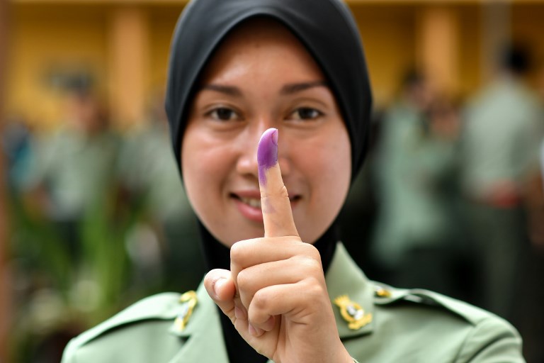 A Malaysian Army forces shows her inked finger after casting her vote during an early vote for the 14th general election in Kuala Lumpur on May 5, 2018.
Malaysia’s 14th general election will be held on May 9. / AFP PHOTO / Manan VATSYAYANA