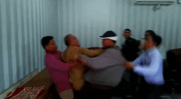 Karawang legislator Hitler Nababan, wearing pink, being shielded as an angry mob is about to attack him. Photo: Video screengrab