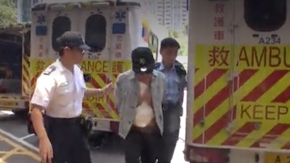 The suspect being led away by authorities. Picture: Apple Daily screen grab