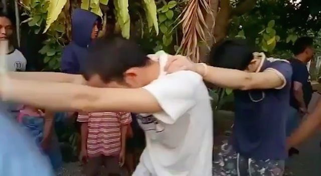 Chinese cyber fraud suspects get marched in front of press photographers after their arrest on May 1, 2018. Photo via Info Badung