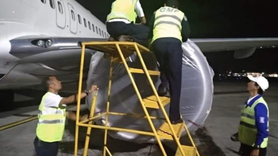 Ground staff secure the plane, anticipating ash fall at Bali’s airport. Photo: BNPB