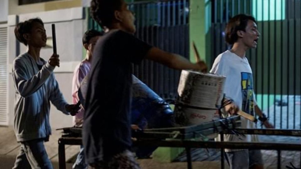 In this photograph taken early on May 19, 2018, youths sing and bang on improvised drums as they walk around their neighborhood to wake up residents for Sahur, the pre-dawn meal eaten before the start of the fasting day throughout the holy month of Ramadan, in Jakarta. Most of Jakarta is fast asleep at 2:00 am, but for Fajar Ramadin and his pint-sized comrades it’s time to wake up the neighbourhood. The motley group of children yell and bang on tambourines and drums as they roam the quiet streets of Indonesia’s capital on a mission to stir sleeping residents for a pre-dawn meal. BAY ISMOYO / AFP