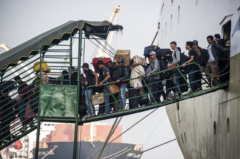 Passengers disembark from a ship on arrival at the Surabaya port in East Java on June 11, 2018, as people travel to their hometowns to celebrate the Eid al-Fitr festival to mark the end of the holy month of Ramadan. AFP/Juni Kriswanto