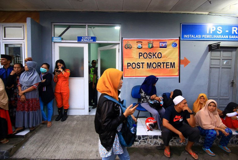 Relatives gather at the mortuary to identify their loved ones after a packed traditional wooden boat capsized during a short journey to the resort island of Barrang Lompo, in Makassar, provincial capital of South Sulawesi, on June 13, 2018. AFP/Wawan