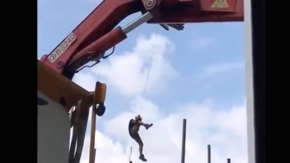 A screengrab via YouTube of the worker dangling from a crane at a construction site in Tseung Kwan O