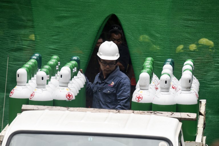 Rescue workers move air tanks at the Tham Luang cave area as operations continue for the 12 boys and their coach trapped at the cave in Khun Nam Nang Non Forest Park in the Mae Sai district of Chiang Rai province on July 8, 2018. Photo: AFP
