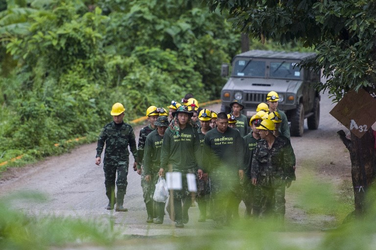 Thai soldiers walk out from the Tham Luang cave area as operations continue for the 8 boys and their coach trapped at the cave in Khun Nam Nang Non Forest Park. Photo: AFP