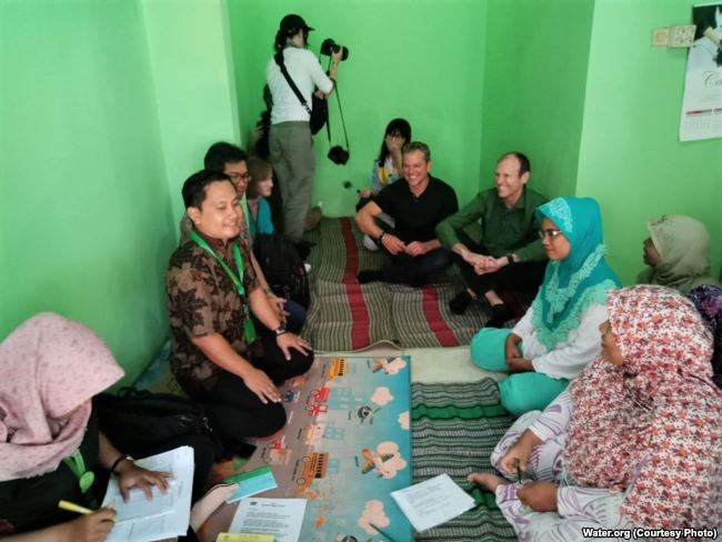 Matt Damon and Gary White with members of Komida in Batang. Photo courtesy of Water.Org