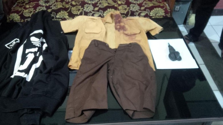 School uniform worn by victim FNM during his fight with a classmate and the pair of scissors used against FNM in the fatal incident. Photo: Istimewa/Detik