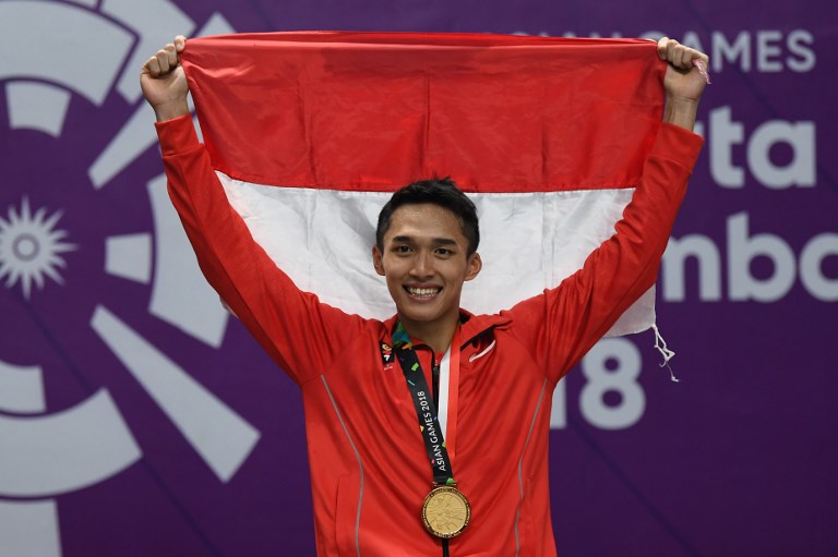 Gold medallist Indonesia’s Jonatan Christie celebrates during the awards ceremony for the men’s singles badminton event at the 2018 Asian Games in Jakarta on August 28, 2018. / AFP PHOTO / SONNY TUMBELAKA