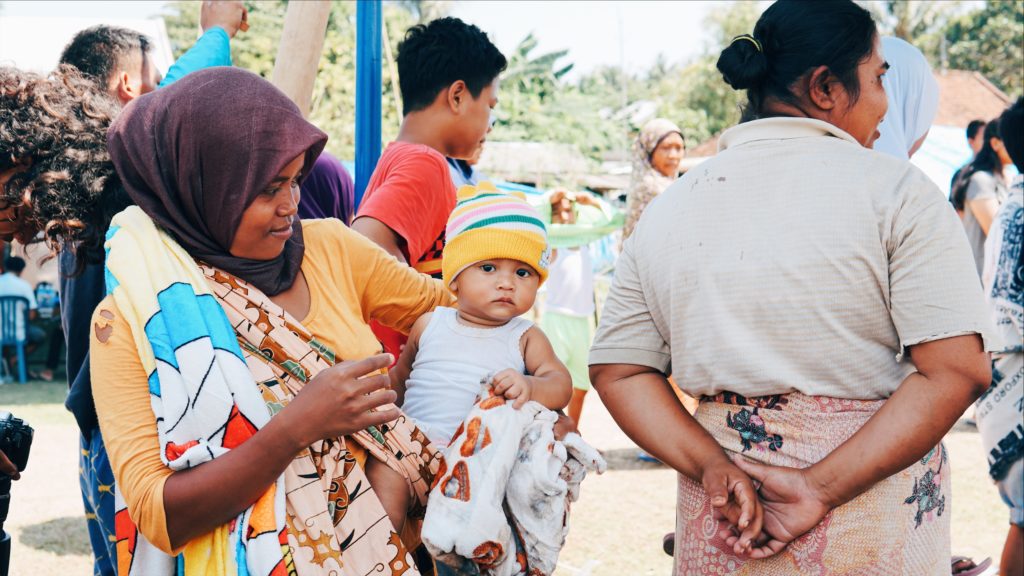 A mother and her baby wait in line for a medical checkup from the Bumi Sehat team at an evacuation camp in West Lombok. Photo: Coconuts Bali