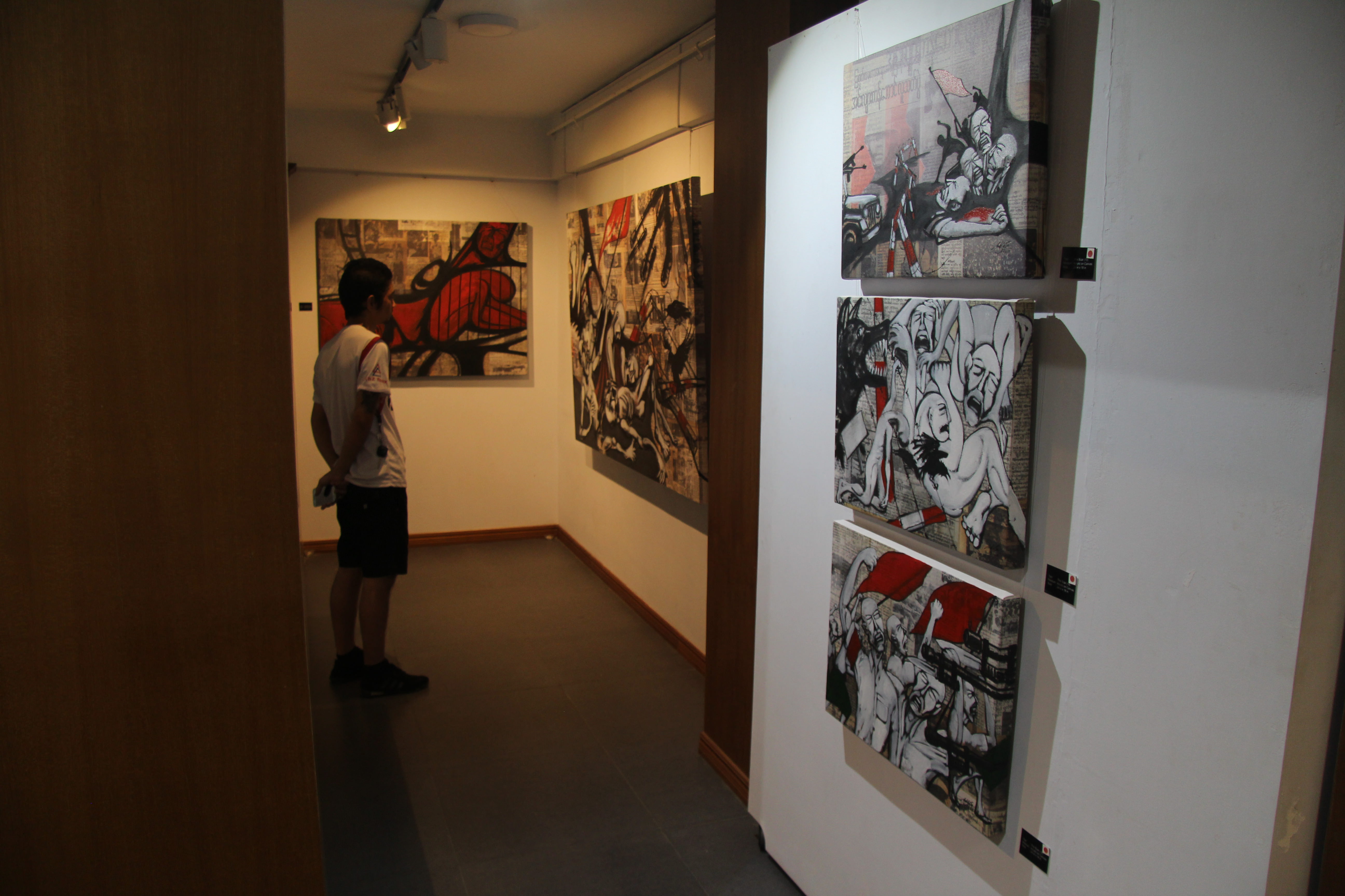 A visitor at Aung Kyi Soe’s Scar exhibition at Yangon’s OK Art Gallery on Aug. 8, 2018. Photo: Jacob Goldberg