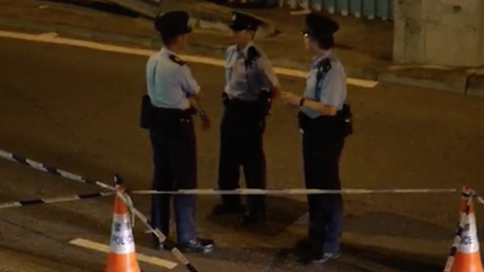 Police standing at the scene in Tun Muen last night. Picture via screengrab from Apple Daily