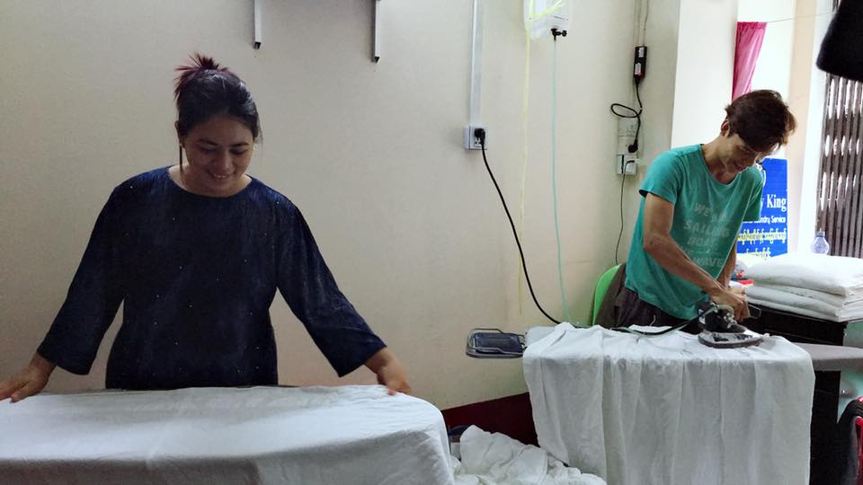 Ma Sandar and her husband Ko Sithu work at their laundromat in downtown Yangon. Photo: Facebook / Sandar Win Aung