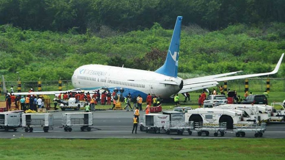 A XiamenAir Boeing 737-800 series passenger aircraft, operating as flight MF8667 from Xiamen to Manila, is seen after skidding off the runway while attempting to land in bad weather at the Manila international airport. Wet passengers (left) with blankets line up at the immigration counter after getting out of the disabled Xiamen aircraft. AFP / Jerry S. Tan