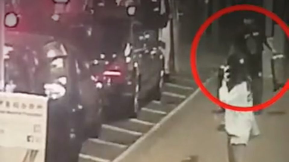 An image of one of the robbers taking suitcases full of cash from the victims caught by CCTV. Image via Apple Daily (screengrab)