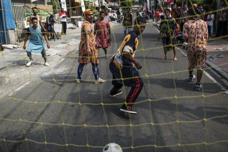 People play soccer in Jaksa street to cover traditional games as part of the 2018 Asian Games in Jakarta on August 17, 2018. From football match to greasy pole climbing, one day before the start of the Asian Games, locals in Jakarta has changed the alley in downtown to the competition venues as part of the country's independence day celebration.FRED DUFOUR / AFP