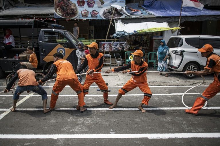 Indonesian worker play a tug of war game in Jaksa street to cover traditional games as part of the 2018 Asian Games in Jakarta on August 17, 2018. From football match to greasy pole climbing, one day before the start of the Asian Games, locals in Jakarta has changed the alley in downtown to the competition venues as part of the country’s independence day celebration.
FRED DUFOUR / AFP