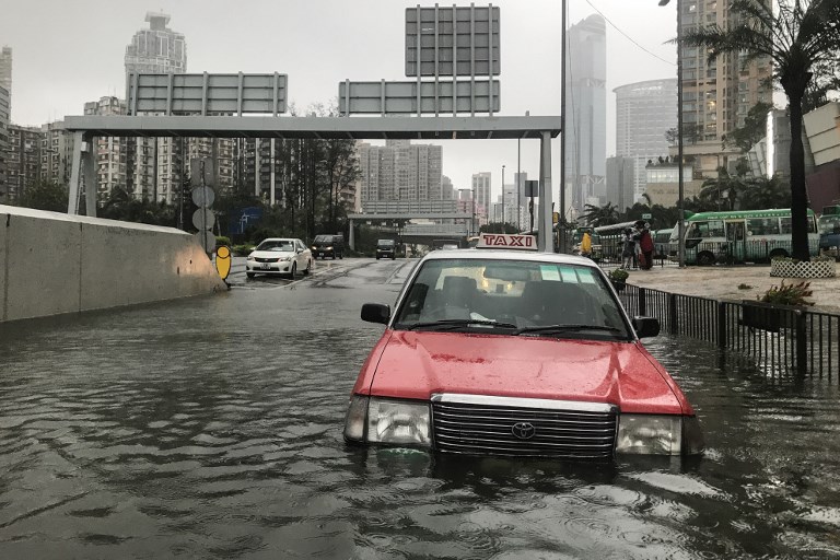 A taxi is abandoned in floodwaters during Super Typhoon Mangkhut in Hong Kong on September 16, 2018.
Typhoon Mangkhut rocked Hong Kong en route to mainland China on September 16, injuring scores and sending skyscrapers swaying, after killing at least 30 people in the Philippines and ripping a swathe of destruction through its agricultural heartland. / AFP PHOTO / Anthony WALLACE