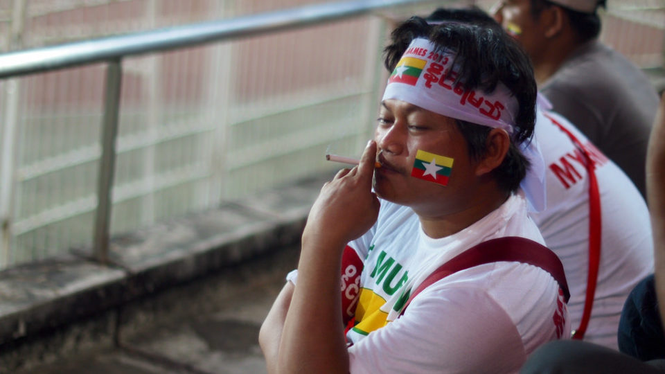 A man smokes in a Yangon football stadium, where smoking is banned. Photo: Flickr / William