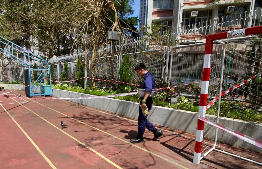 Tse gives chase to a pigeon in a secondary school playground. Coconuts HK