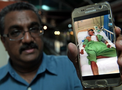 Min Laung in hospital, with his employer via Bernama