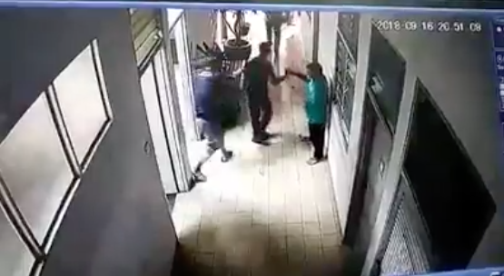 The suspect, in the middle, being apprehended by two others 