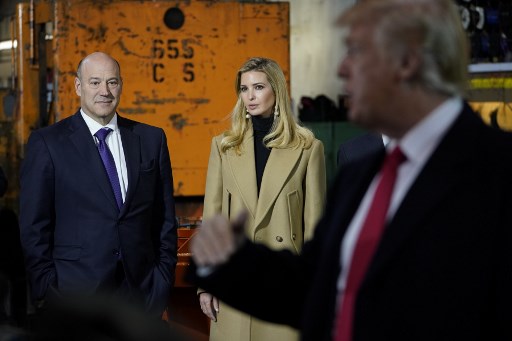 Former Goldman Sachs president Gary Cohn listens as US President Donald Trump speaks during a tour of the H&K Equipment Company in Pennsylvania in January. Cohn signed off on continuing deals with the 1MDB fund. AFP PHOTO / Mandel Ngan