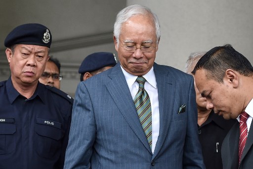 Malaysia’s former prime minister Najib Razak (C) reacts as he leaves Duta court complex in Kuala Lumpur on August 8, 2018. AFP PHOTO / Mohd Rasfan 