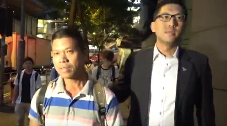Yu Zhulin with Democratic party lawmaker Lam Cheuk-ting walking to the police station after the former turned up at his office.
Screengrab via Apple Daily video.