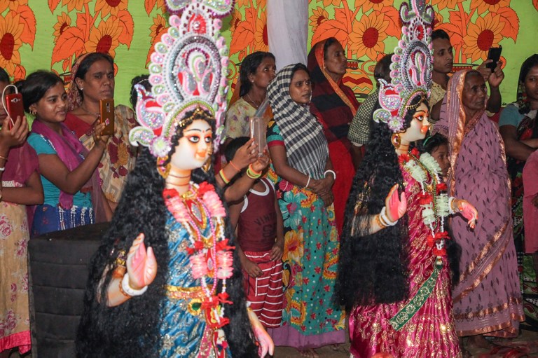 This photo taken on October 18, 2018 shows Hindu refugees from Myanmar gathering to celebrate the Durga Puja festival at the Kutapalong refugee camp in southern Bangladesh. – Hindu refugees from Myanmar living in a southeastern Bangladesh camp were celebrating the Durga Puja festival a year after they were compelled to flee violence in northern Rakhine state. More than 500 Hindus escaped their homes last August along with over 700,000 Rohingya Muslims as Myanmar army launched a brutal crackdown that the UN has said amounted to “ethnic cleansing”. (Photo by Mohammad FARAZ / AFP)