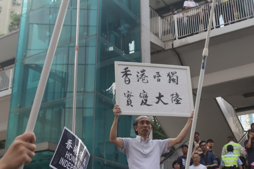Man holding placard that reads 'Hong Kong would become China if it doesn't become independent.' Photo by Vicky Wong.