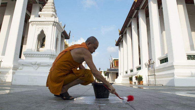 This picture taken on Nov. 16, 2018 shows a Buddhist monk cleaning the grounds of a temple in Bangkok. Photo: Romeo Gacad/ AFP