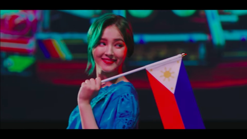 Nancy McDonnie proudly holds the Philippine flag. Screenshot from Baam’s music video.