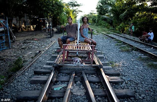 This picture taken on October 17, 2018 shows a family living along a train track in Manila. Scores of commuters in the city of about 12 million are propelled to their destinations daily by so-called “trolley boys” pushing metal carts that ply a few segments of the sprawling capital’s railroads.
Noel CELIS / AFP